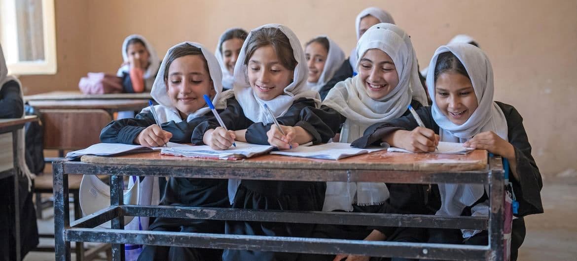 Young Afghan girls attending school in Mazar-i-Sharīf, embracing education and community.